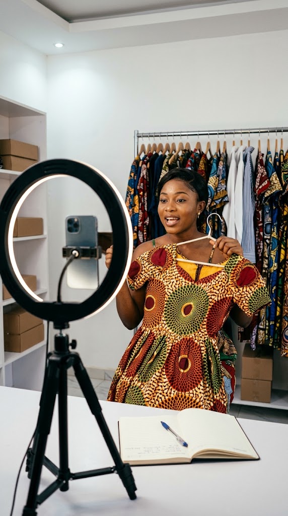 Une vendeuse présente une robe en pagne pendant son live